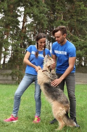 Photo of Volunteers with homeless dog at animal shelter outdoors