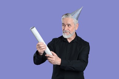Photo of Man with party popper on purple background