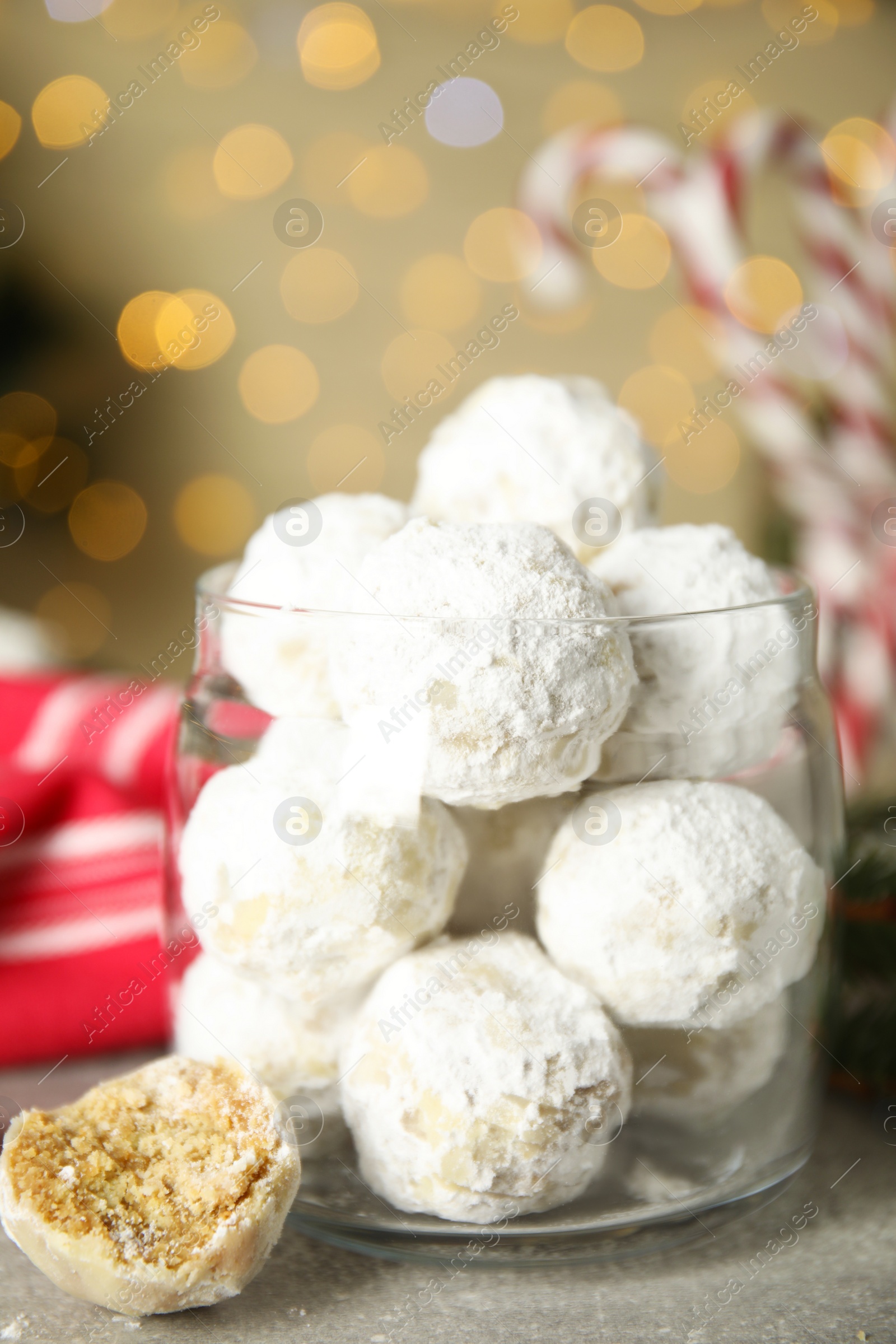 Photo of Tasty snowball cookies in glass jar on grey table. Christmas treat