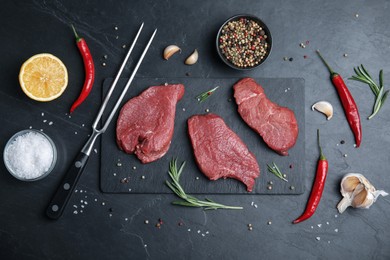 Fresh raw meat steaks and spices on black table, flat lay