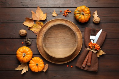 Photo of Seasonal table setting with pumpkins and autumn leaves on wooden background, flat lay. Thanksgiving Day