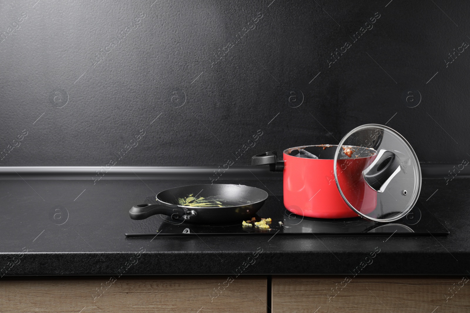 Photo of Dirty pot and frying pan on cooktop in kitchen, space for text