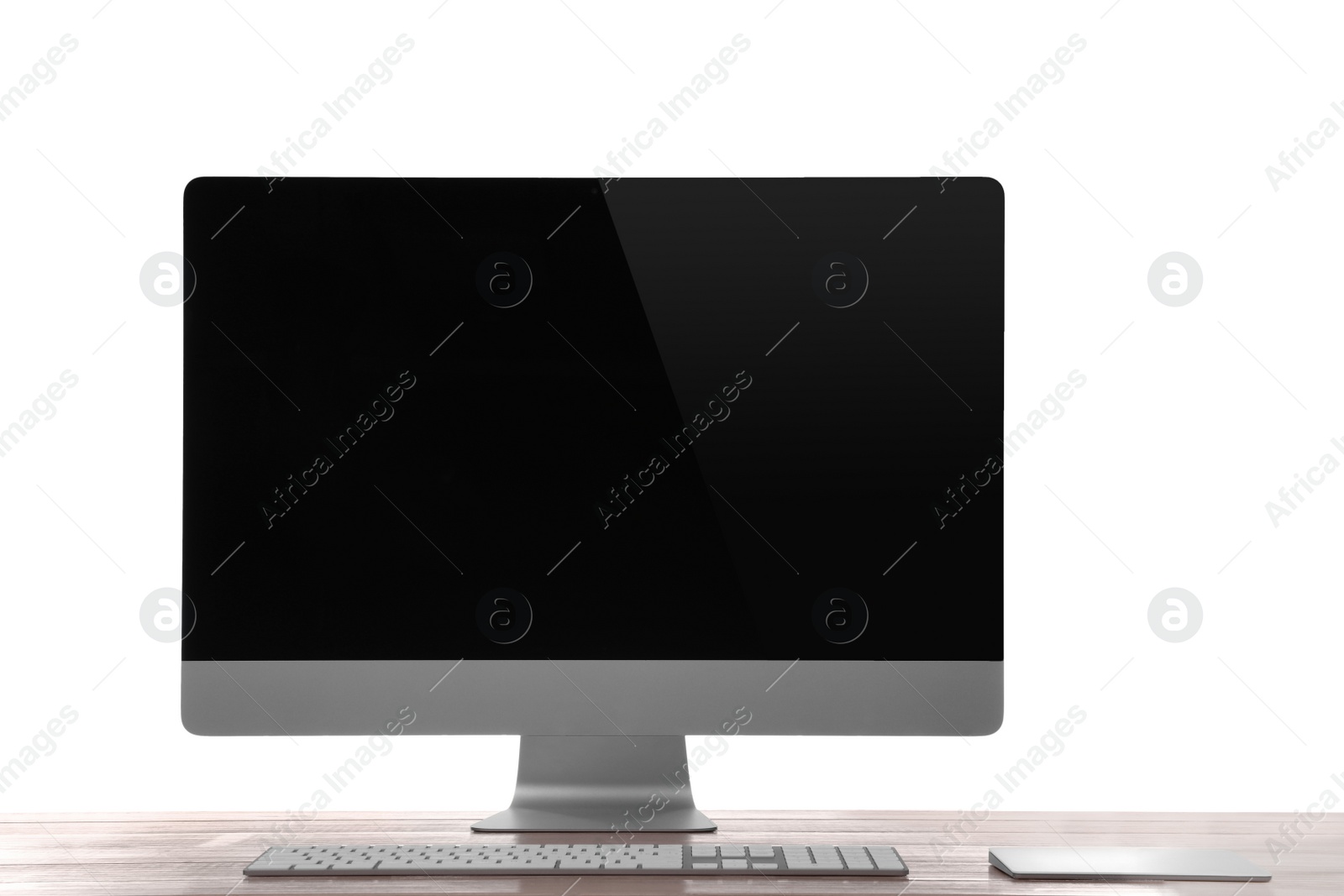 Photo of Modern computer with blank monitor screen and peripherals on wooden table against white background