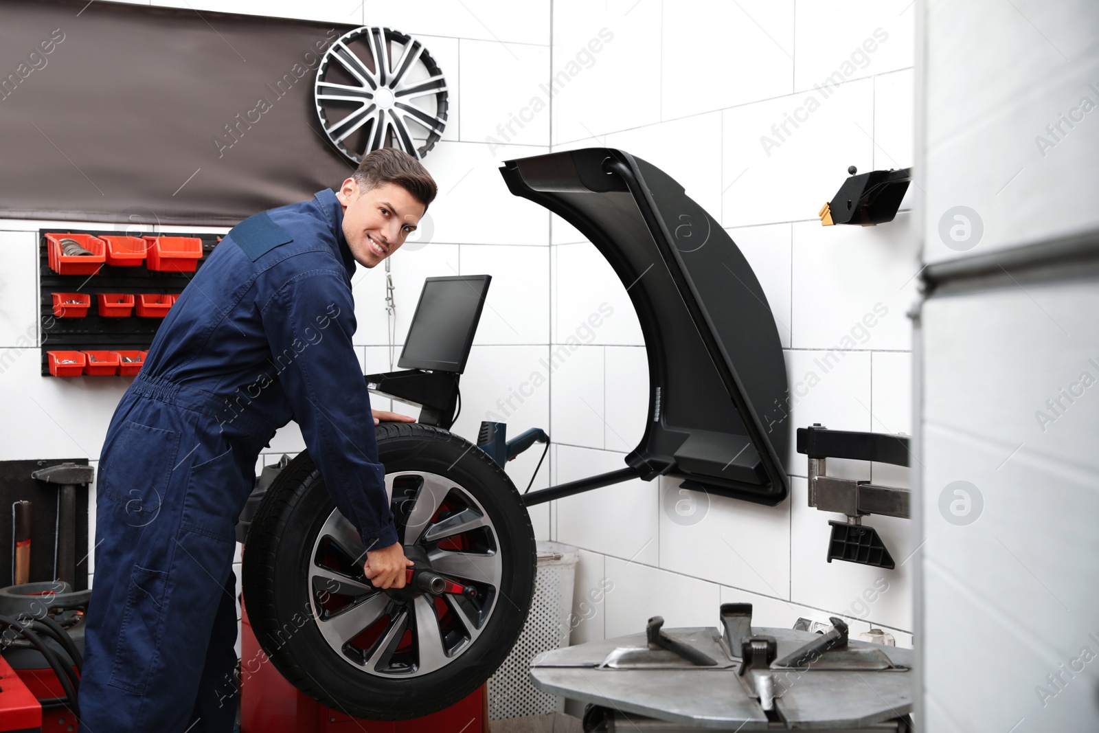 Photo of Man near wheel balancing machine at tire service