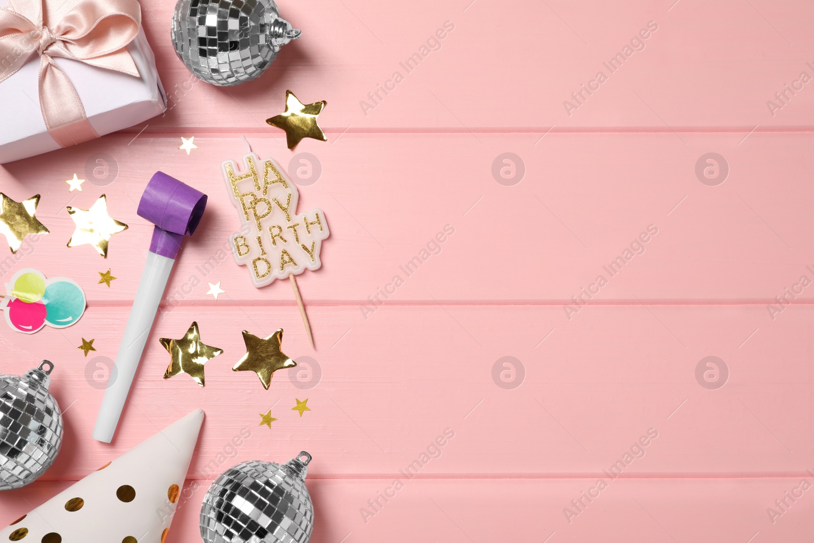 Photo of Shiny disco balls and party decor on pink wooden background, flat lay. Space for text