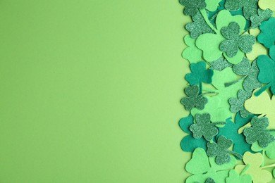 St. Patrick's day. Decorative clover leaves on green background, top view. Space for text