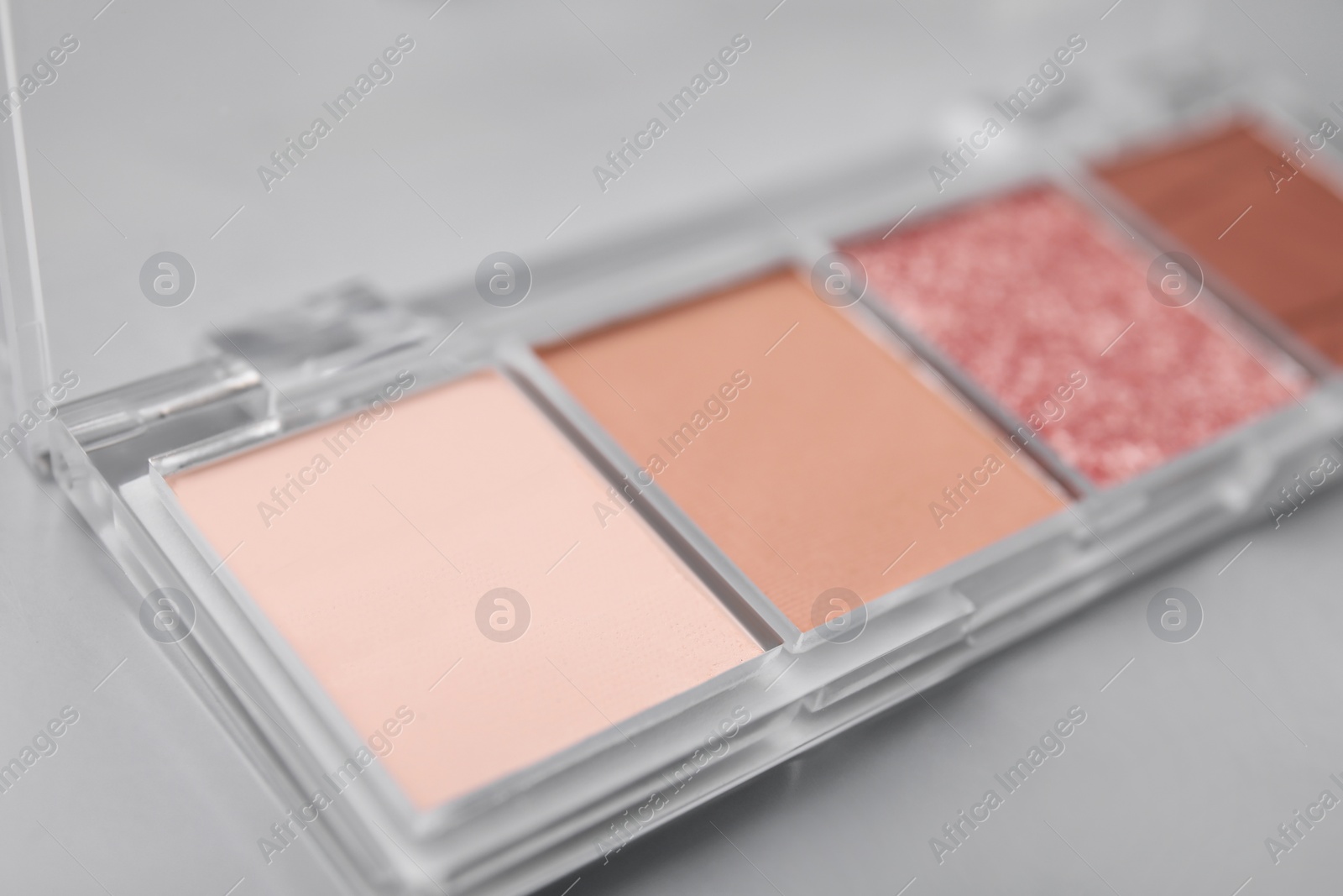 Photo of Beautiful eyeshadow palette on light gray background, closeup. Professional cosmetic product