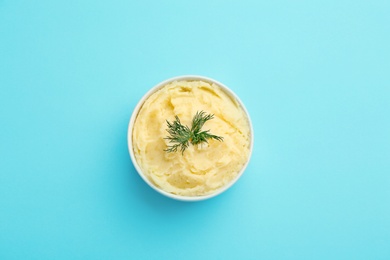 Bowl with tasty mashed potatoes on color background, top view