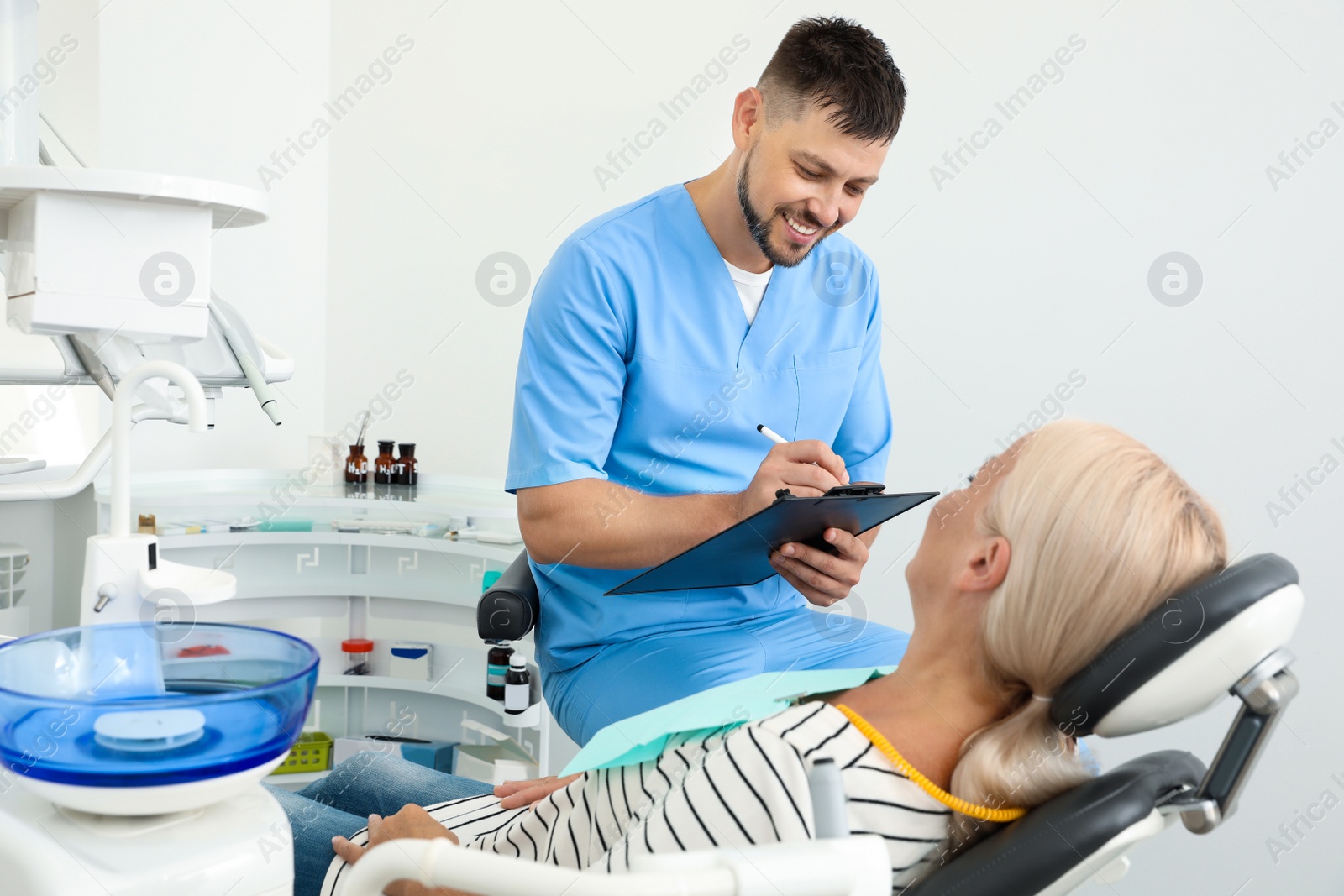 Photo of Professional dentist working with patient in clinic