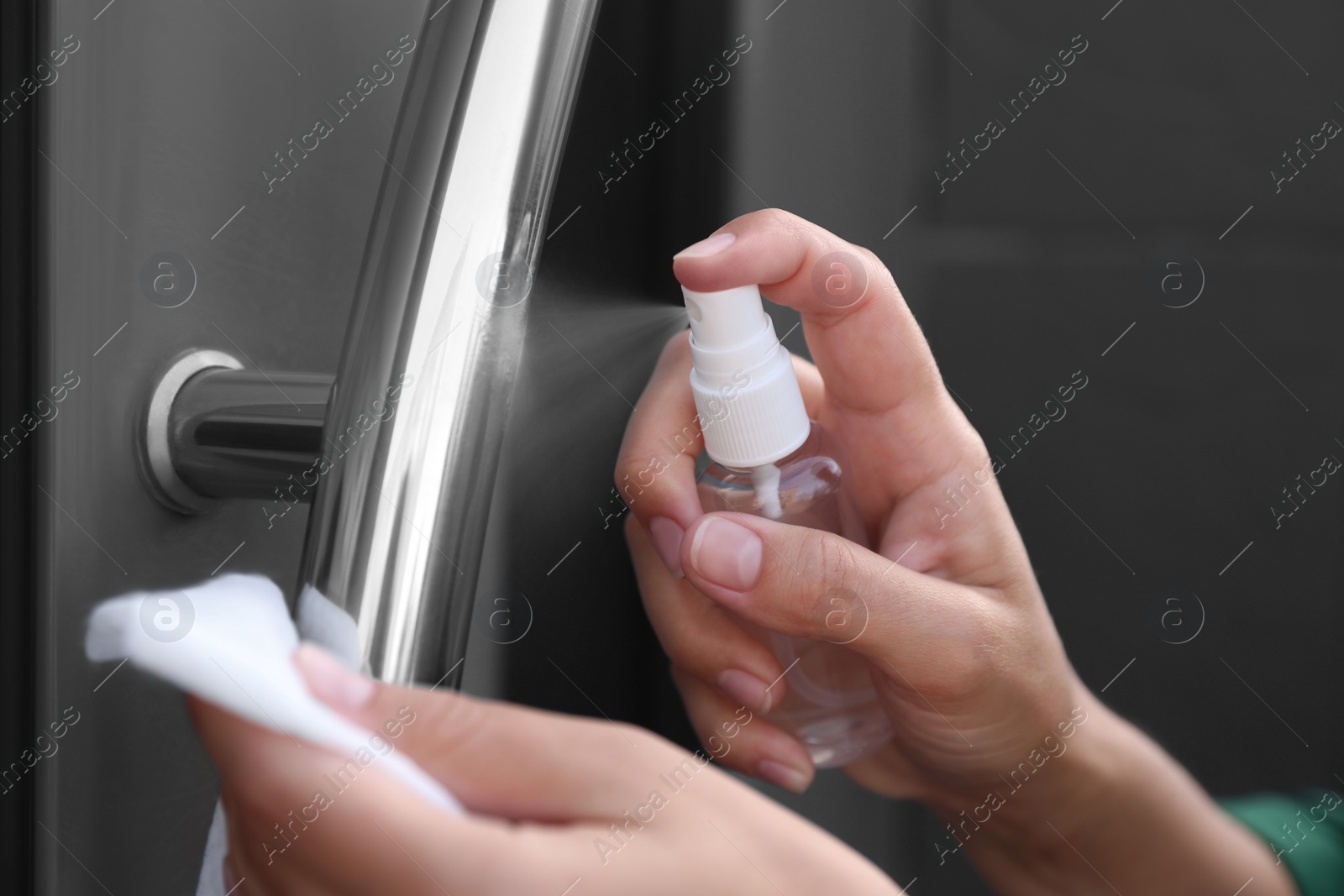 Photo of Woman cleaning door handle with wet wipe and antiseptic outdoors, closeup