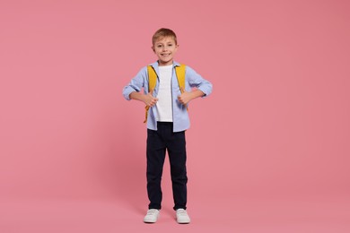 Photo of Happy schoolboy with backpack on pink background