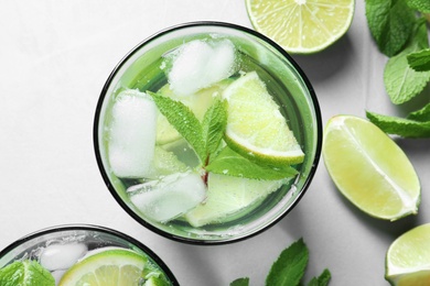 Refreshing beverage with mint and lime in glass on table, top view