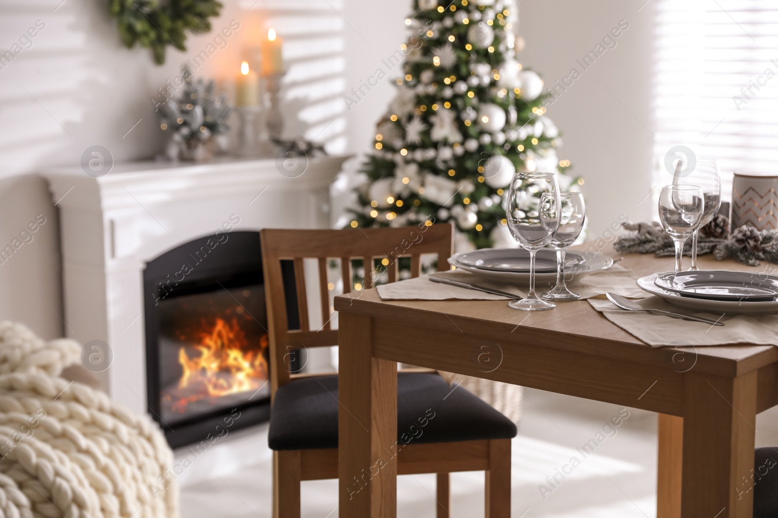 Photo of Festive table setting and beautiful Christmas decor in living room. Interior design