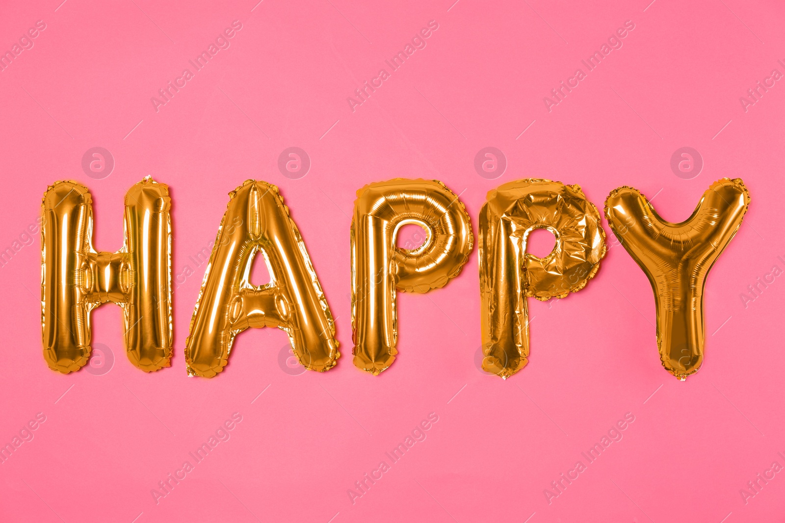 Photo of Word HAPPY made of golden foil balloons letters on pink background