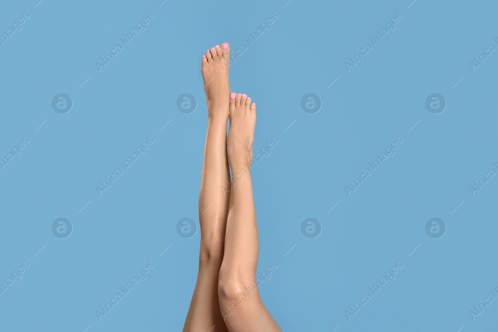 Photo of Woman with beautiful long legs on light blue background, closeup