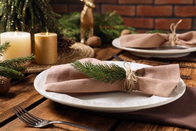 Photo of Festive place setting with beautiful dishware, cutlery and fabric napkin for Christmas dinner on wooden table