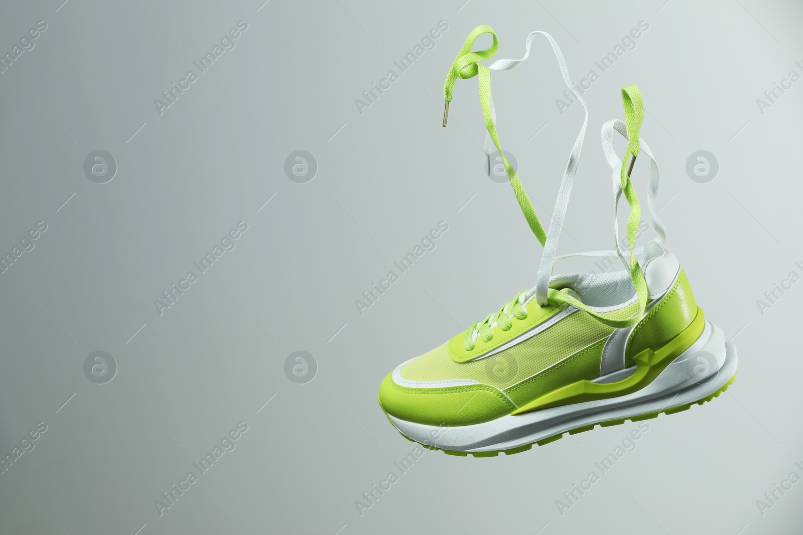 Photo of Stylish sneaker on light grey background. Space for text