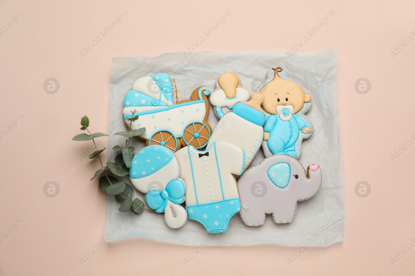 Photo of Set of baby shower cookies on light pink background, flat lay