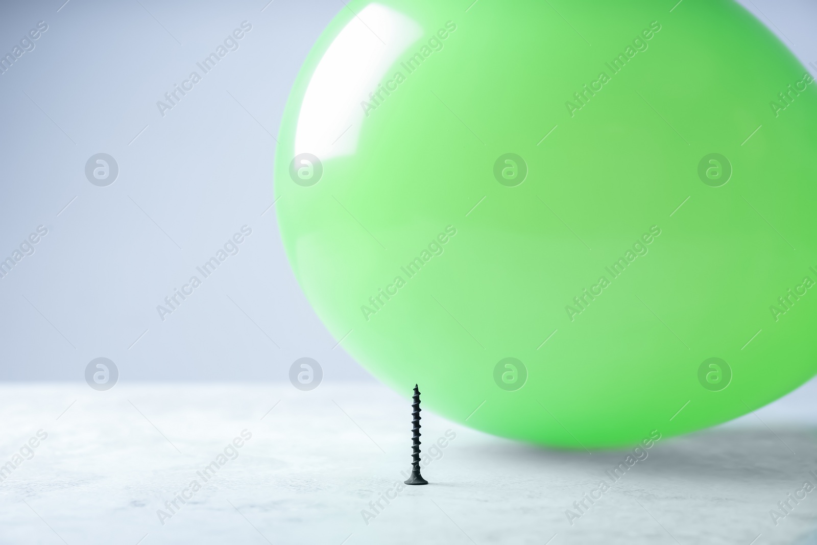 Photo of Color balloon and nail on table against white background, space for text