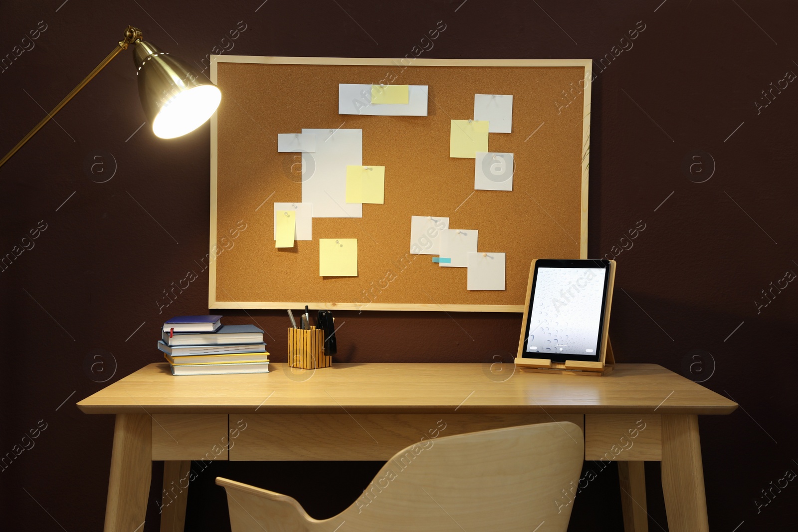 Photo of Stylish workplace with wooden table and cork board