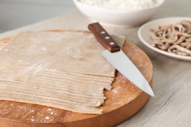 Photo of Making homemade soba (buckwheat noodles) on wooden table, closeup