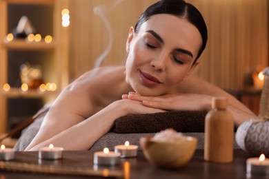 Photo of Spa therapy. Beautiful young woman lying on massage table in salon