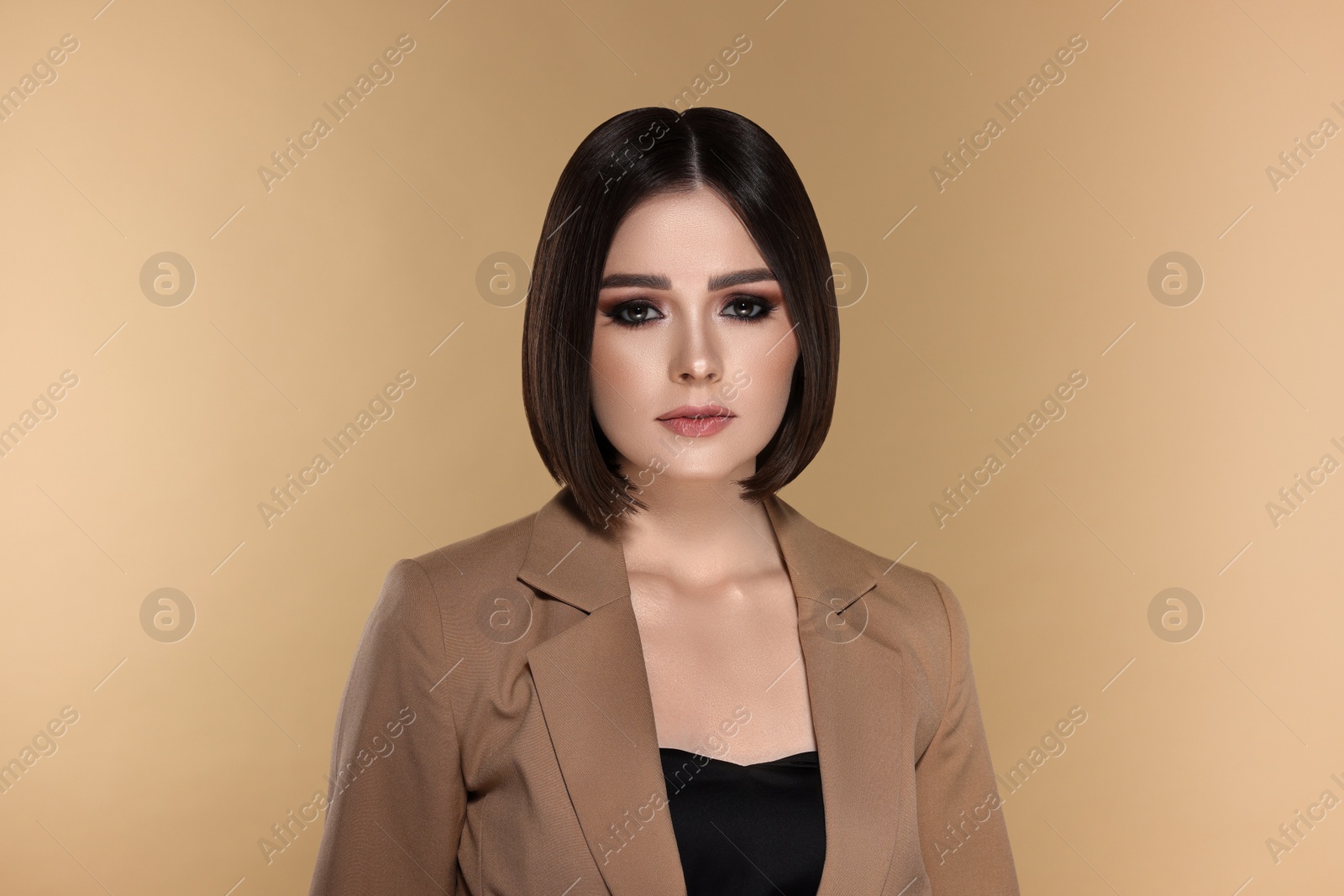 Image of Portrait of stylish young woman with brown hair on beige background