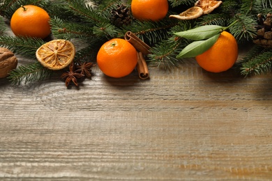 Christmas composition fresh tangerines and fir tree branches on wooden table, space for text