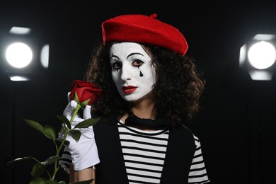 Photo of Young woman in mime costume with red rose performing on stage