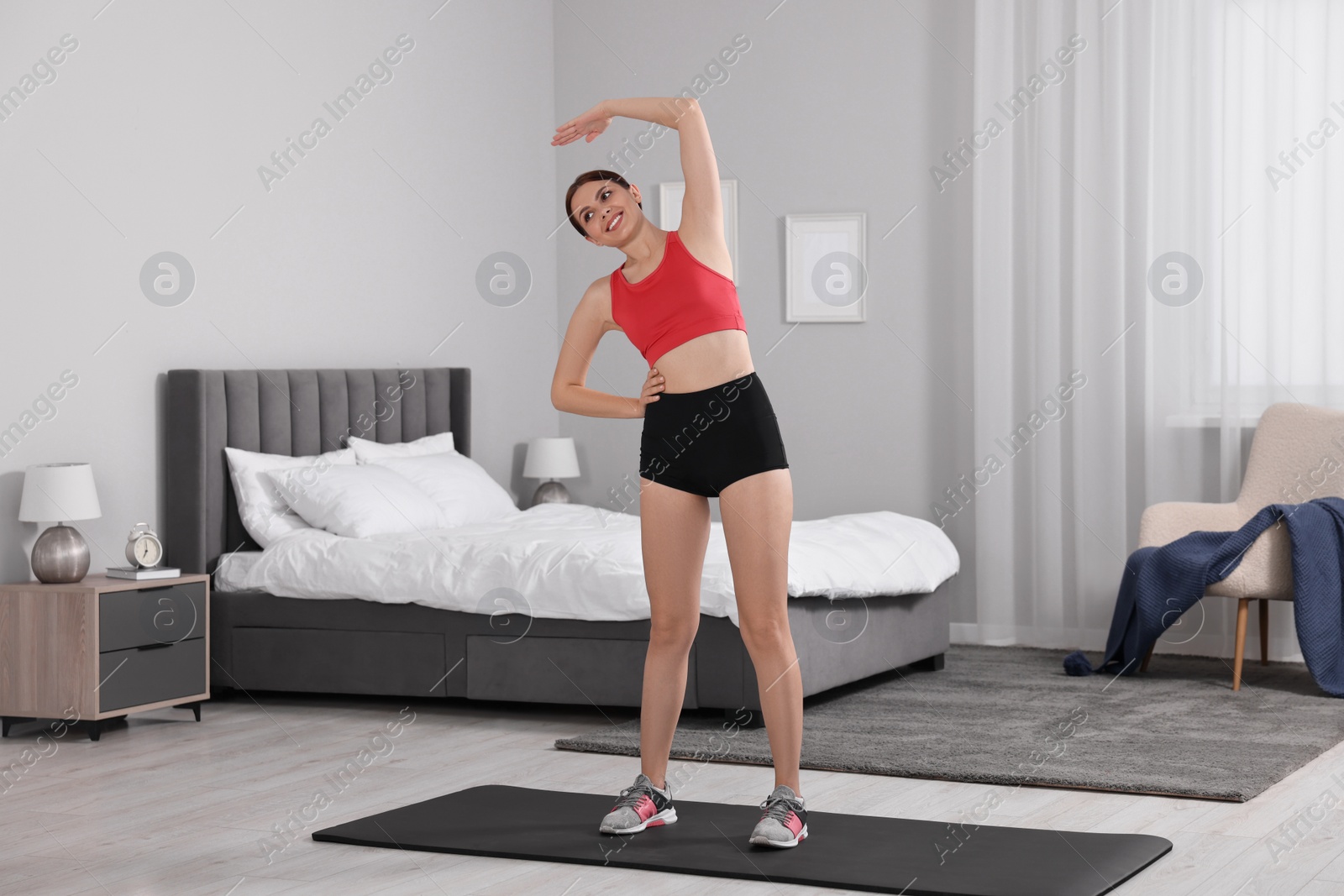 Photo of Morning routine. Happy woman stretching at home