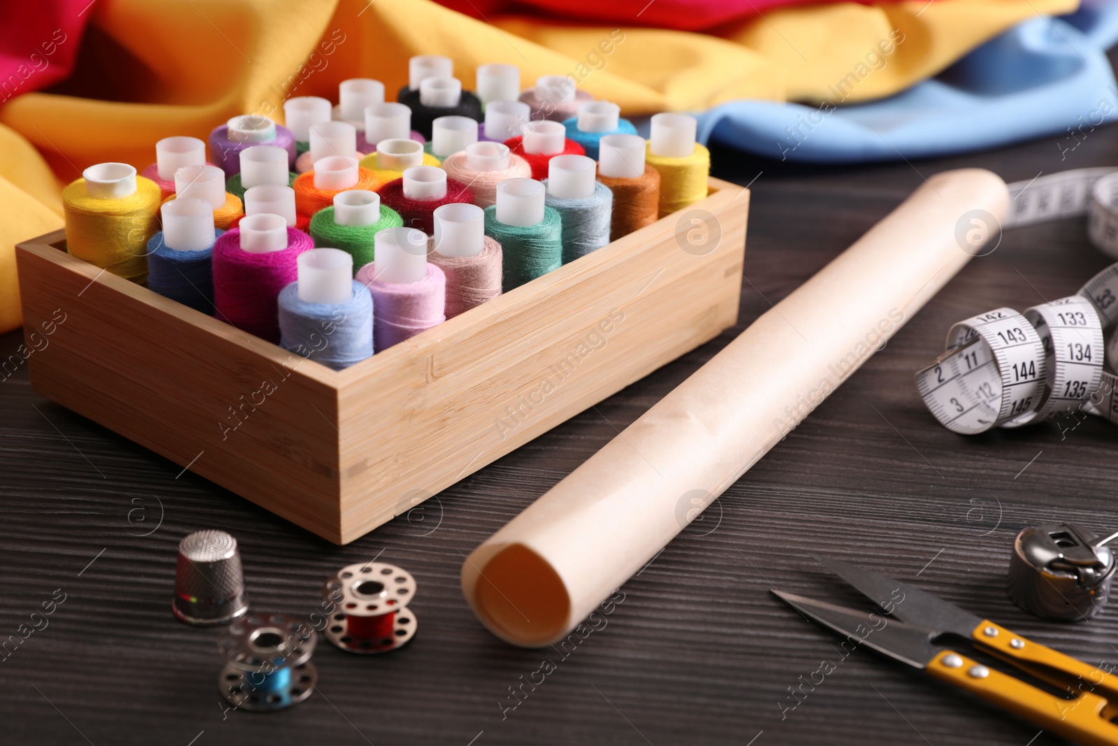 Photo of Set of sewing supplies and accessories on wooden table