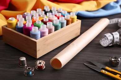 Photo of Set of sewing supplies and accessories on wooden table