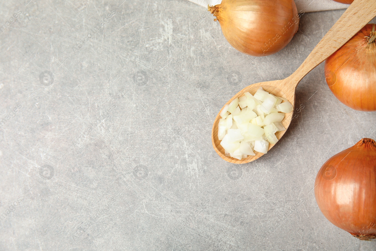 Photo of Flat lay composition with chopped onion and bulbs on grey table, space for text