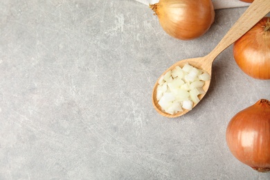 Photo of Flat lay composition with chopped onion and bulbs on grey table, space for text