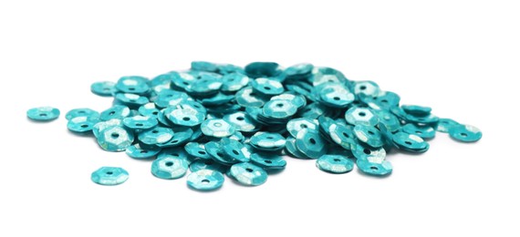 Photo of Pile of turquoise sequins on white background