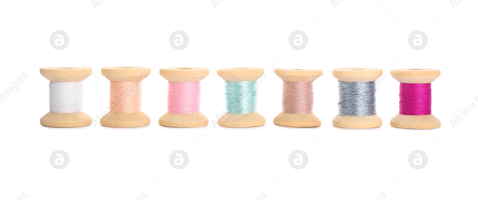 Photo of Set of colorful sewing threads on white background