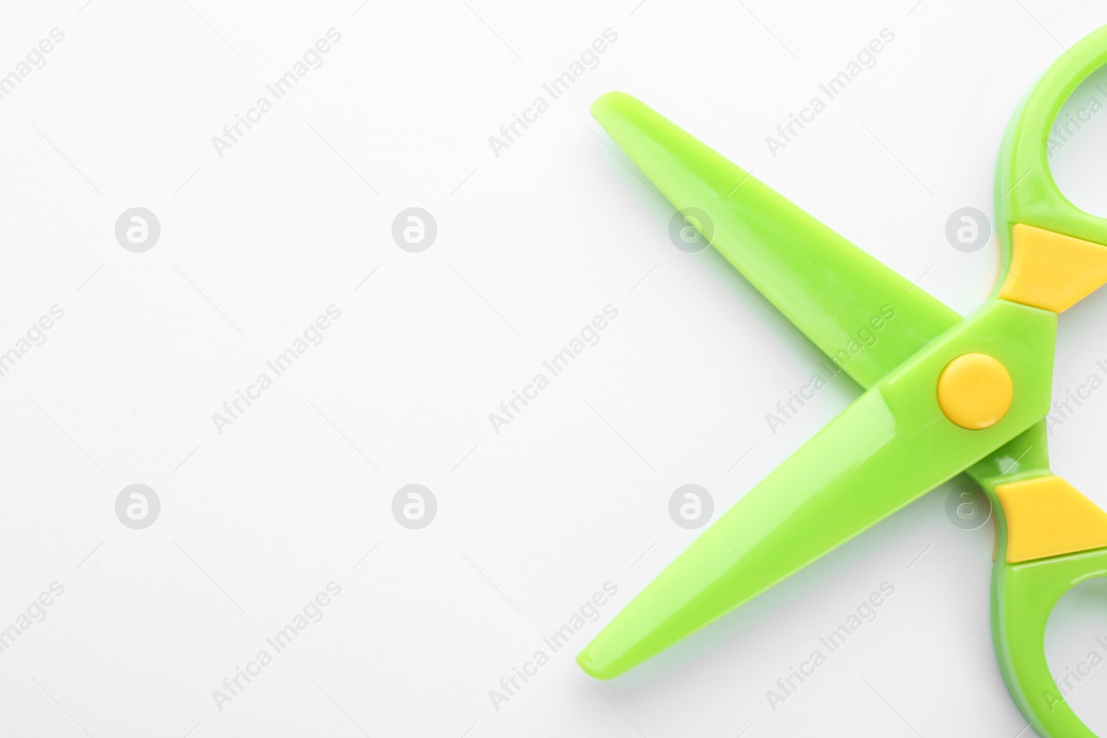 Photo of Colorful plastic scissors on white background. School stationery