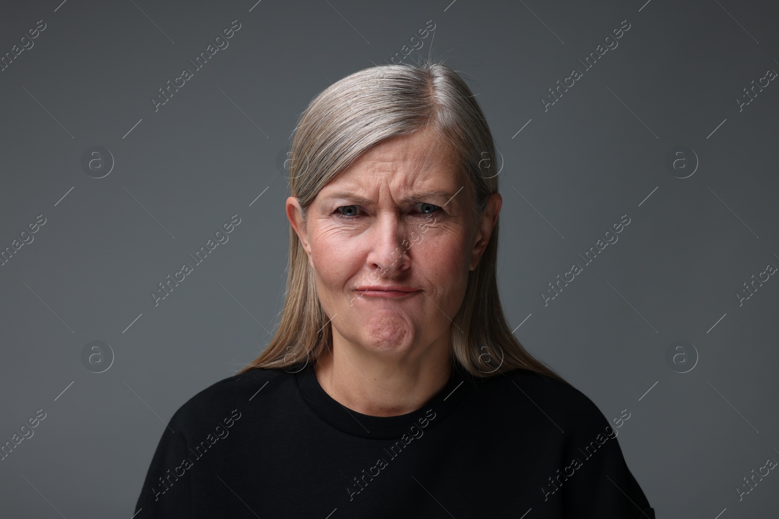 Photo of Personality concept. Portrait of emotional woman on gray background