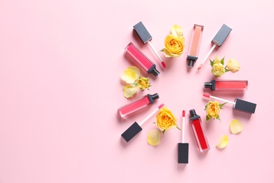 Composition of lipsticks with flowers on color background, flat lay. Space for text.