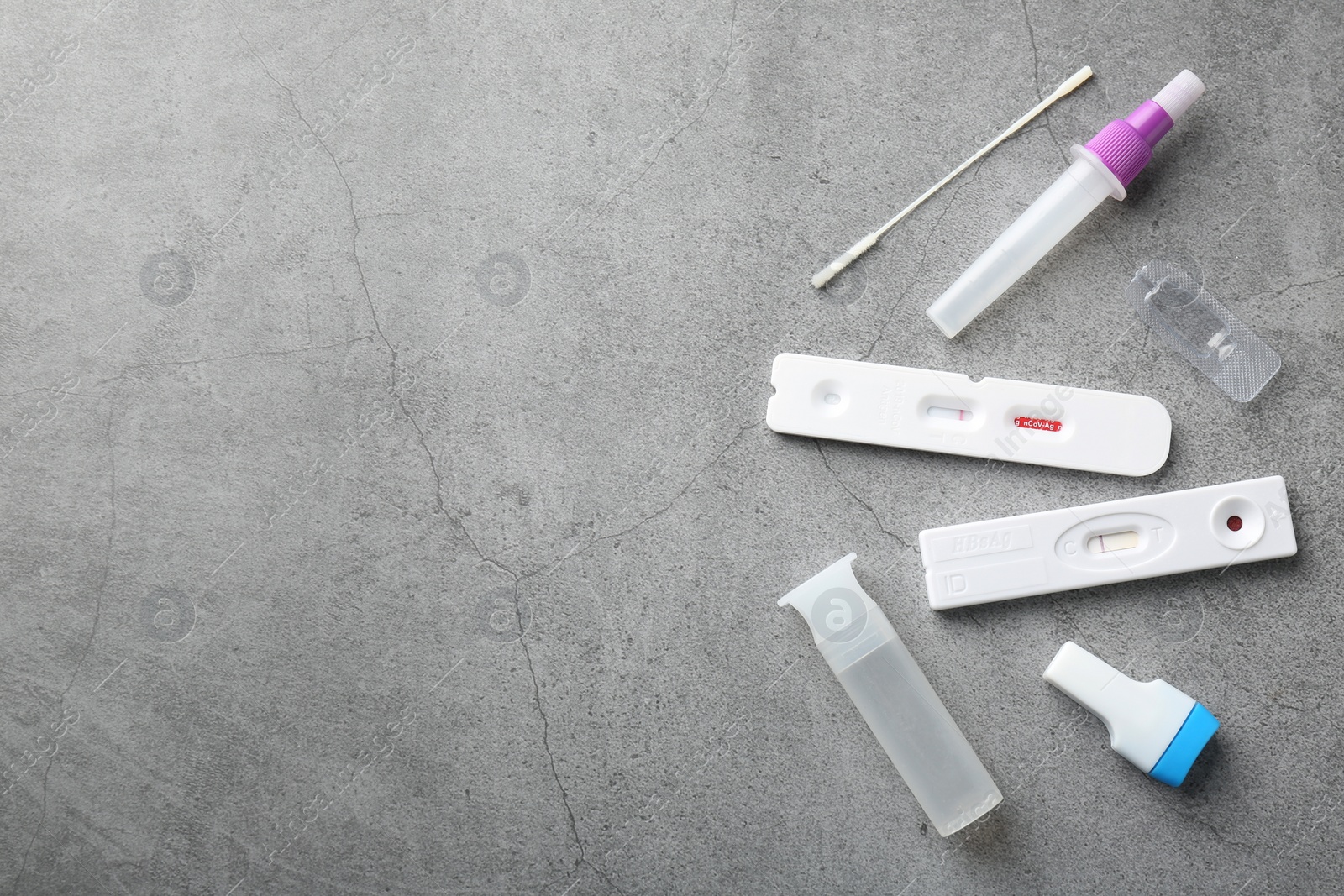 Photo of Disposable express test kits on grey table, flat lay. Space for text