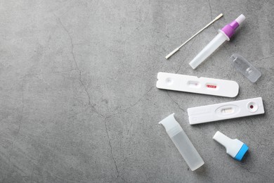 Photo of Disposable express test kits on grey table, flat lay. Space for text