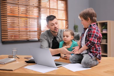 Overwhelmed man combining parenting and work at home