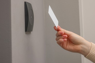 Photo of Woman opening magnetic door lock with key card, closeup. Home security