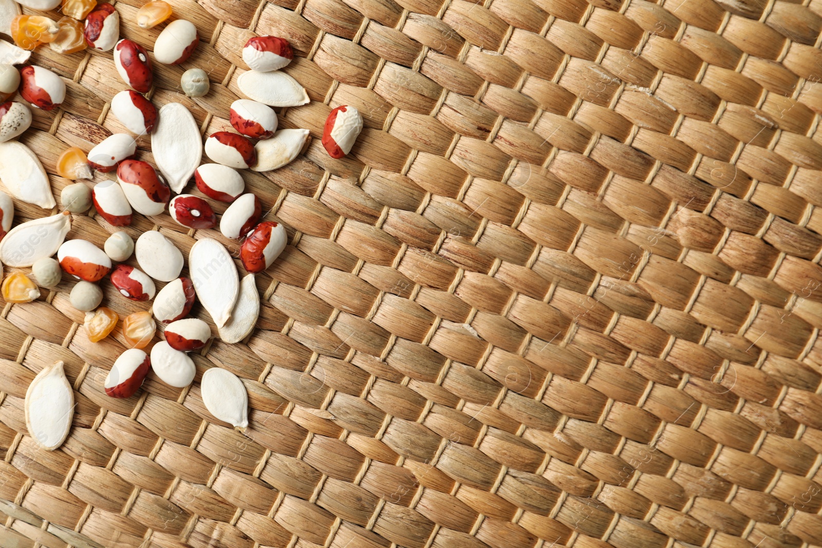 Photo of Mixed vegetable seeds on wicker background, flat lay. Space for text