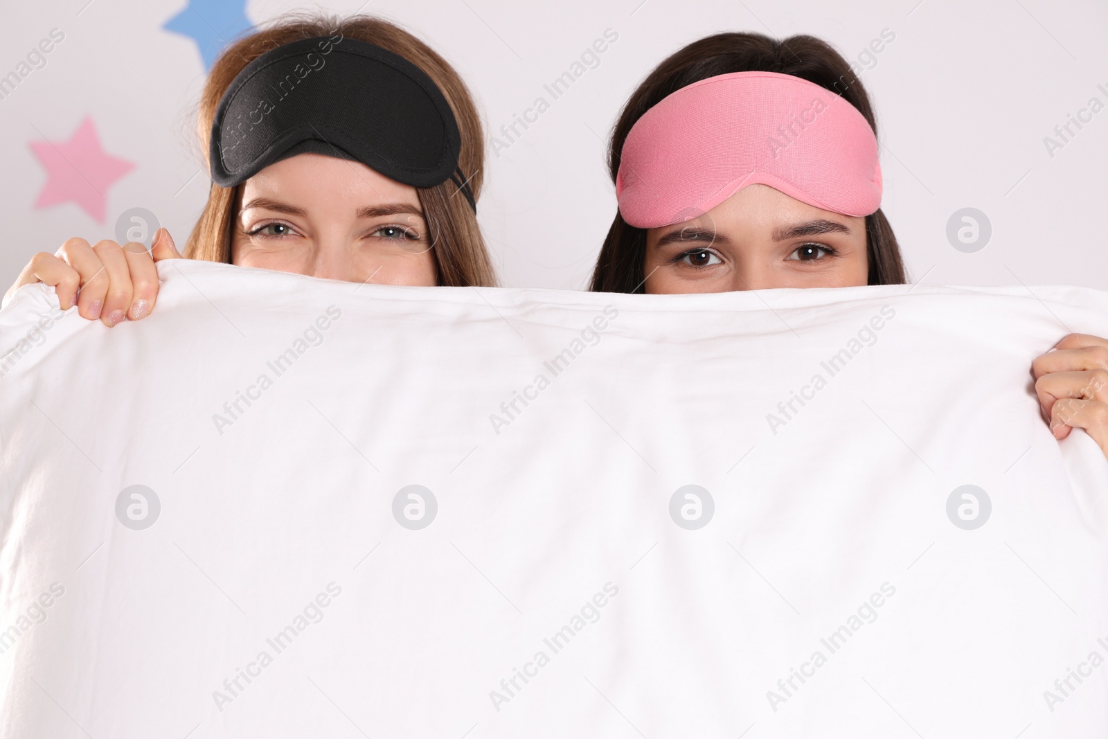 Photo of Beautiful women with pillow on light grey background. Bedtime