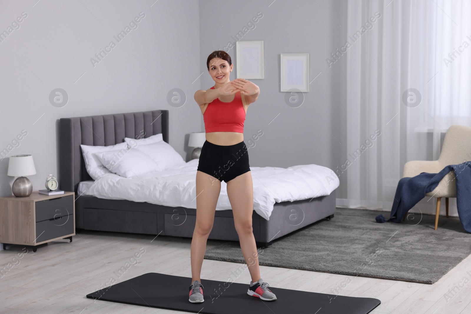 Photo of Morning routine. Happy woman stretching at home