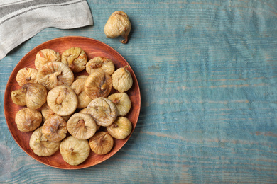 Tasty dried figs on light blue wooden table, flat lay. Space for text