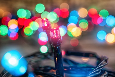 Beautiful bright Christmas lights on table, closeup