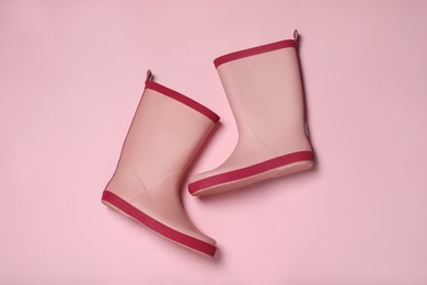 Photo of Pink rubber boots on color background, flat lay