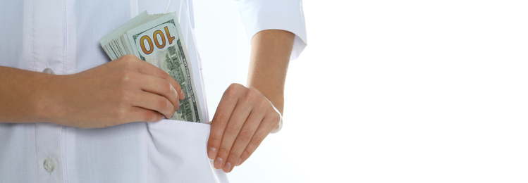Doctor putting bribe into pocket on white background, closeup. Banner design